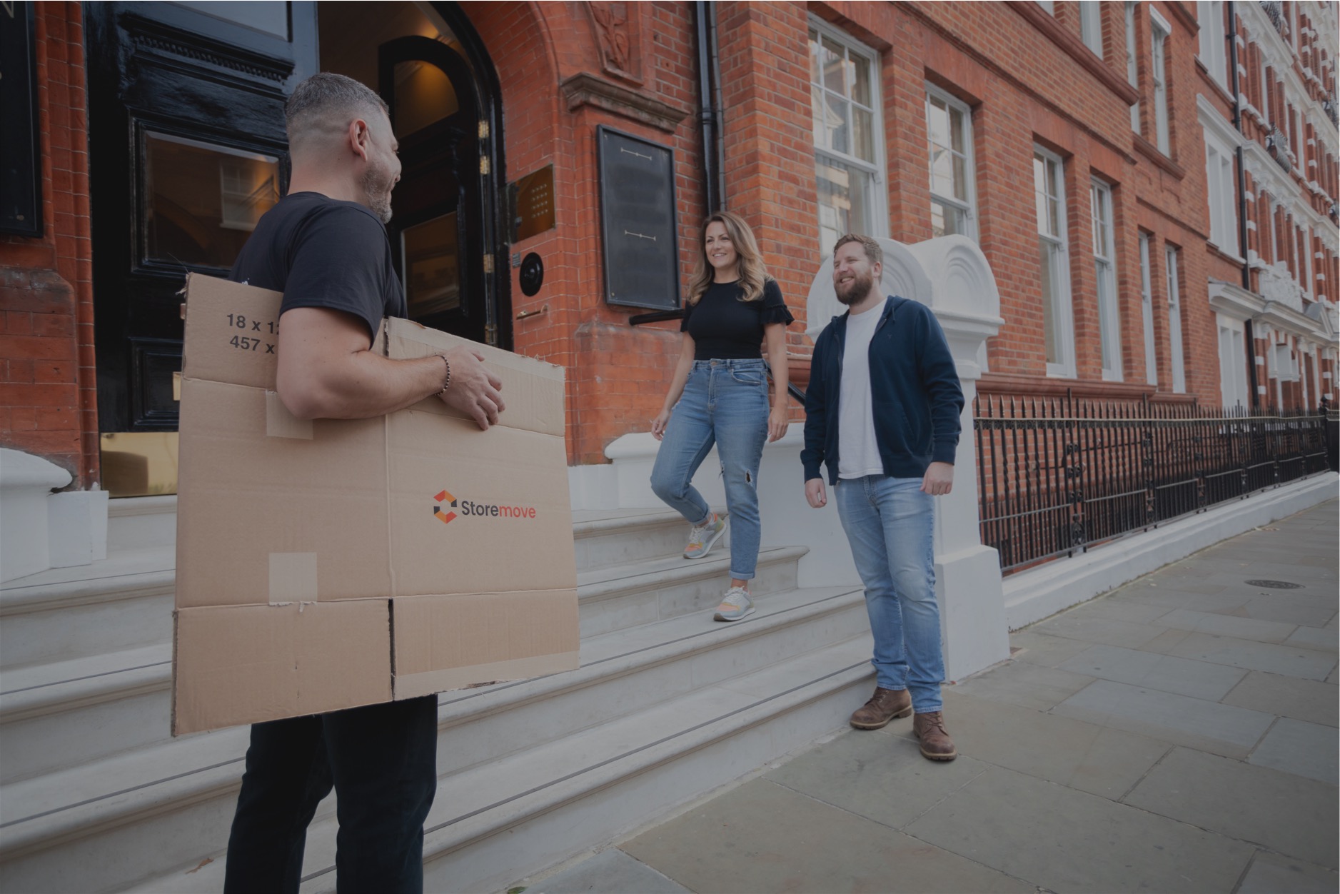 People carrying moving boxes outside a London townhouse � Storemove collection and delivery service